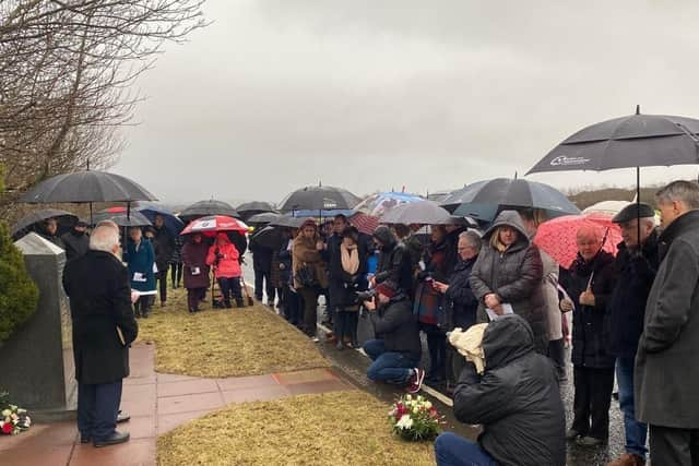 Family and friends during the anniversary service of the Teebane bombing outside Cooktown on Sunday.