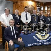 Mayor of Causeway Coast and Glens, Councillor Steven Callaghan alongside the winners of the Irish Senior Cup standing behind a table their many trophies.