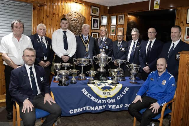 Mayor of Causeway Coast and Glens, Councillor Steven Callaghan alongside the winners of the Irish Senior Cup standing behind a table their many trophies.