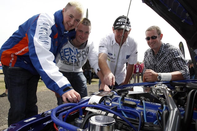 Shane, Martin and Hugh Dobbin and Aidy McHemphill looking at a car engine during the Ford Fair in Portrush back in 2010