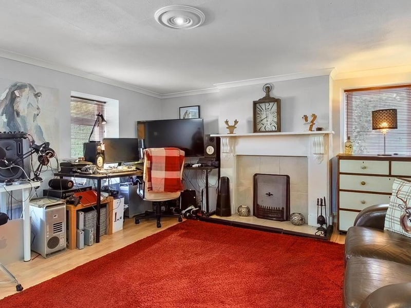 Lounge with open fire in tiled fireplace with timber surround.