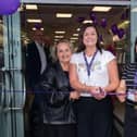 Menarys manager, Lynette Young, centre, cuts the ribbon to officially open the company's new Lurgan store with the help of sales assistants, Shirley Graham, left, and Sharon Kelly. LM18-204.