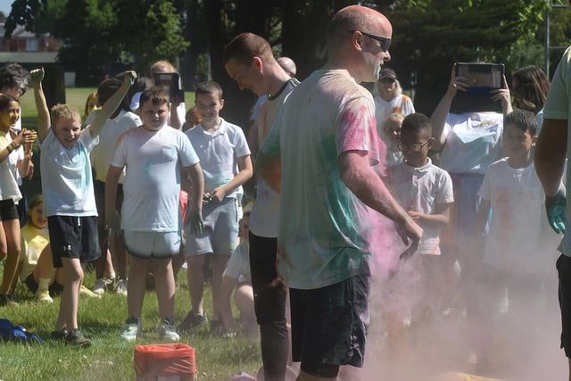 Ballyoran Primary School principal, Mr Richard Woolsey gets covered in coloured powder at the start of the school colour run. PT21-202.