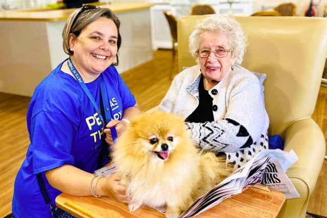 A Pets As Therapy volunteer bringing their dog to their local care home to spend time with residents