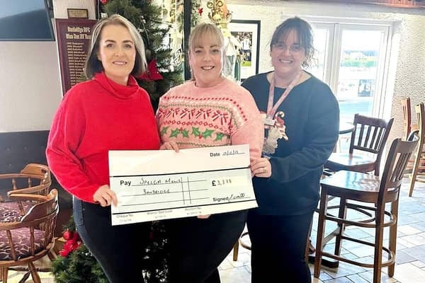 Emma O'Neill presents the cheque to Spelga Mews manager Louise McConville & Sarah Maule.