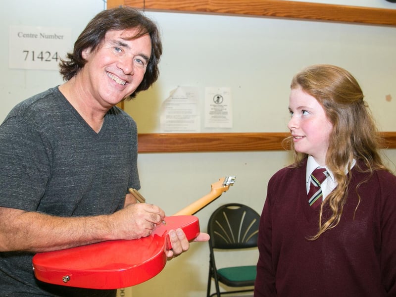 Carl autographs a guitar for Laura Duffin at a workshop. INCT 42-415-RM