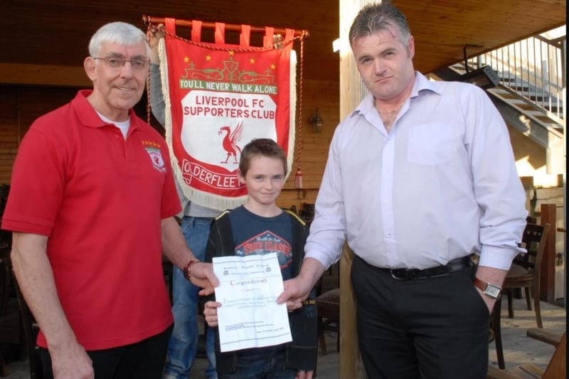 Callum and Eugene Clarke are presented with their match tickets from the PAC ballot by Brian Lilley of the Olderfleet Liverpool Supporters' Club in 2009