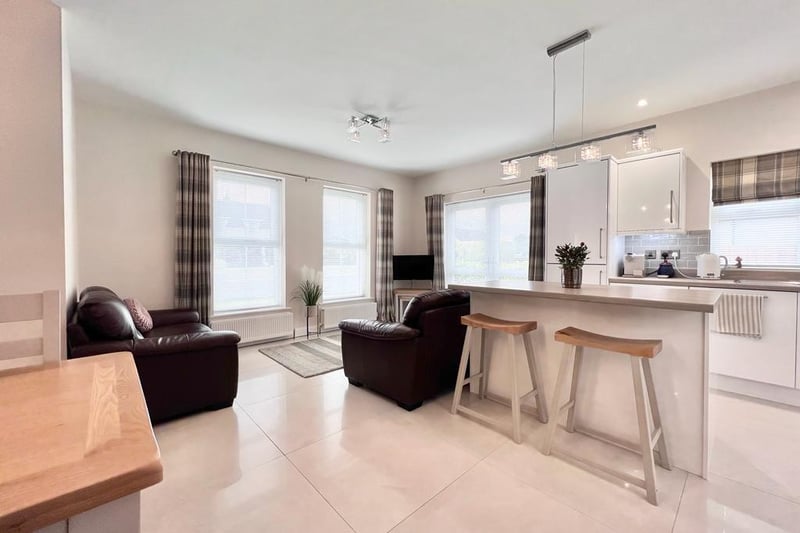 The open plan kitchen / dining / living area features an island with breakfast bar seating - perfect for casual dining and entertaining.