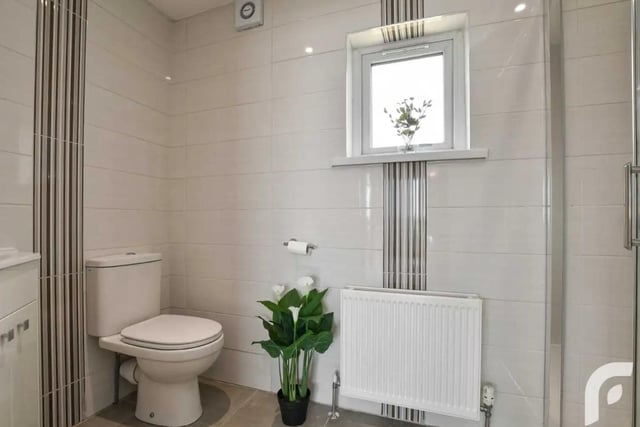 En-suite with walk-in shower, wash hand basin with storage and low flush WC.