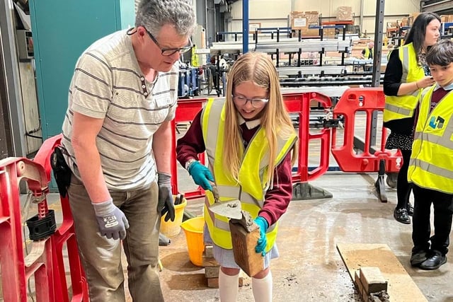 A pupil learns about brick laying at the careers day.