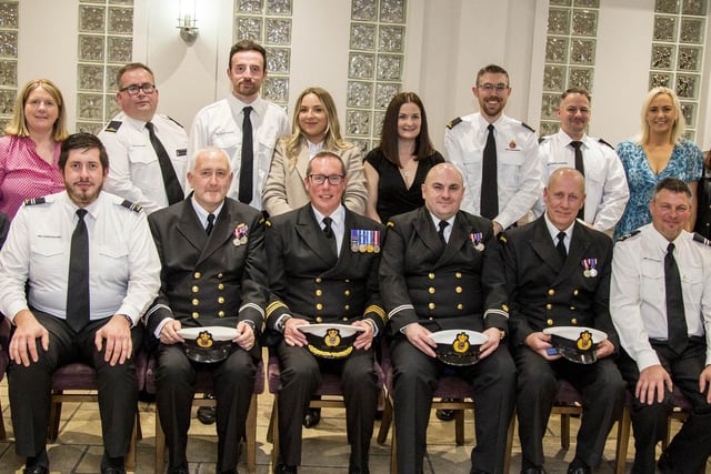 Ballycastle Coastguards Daniel McAuley, Gareth McKellar and Colm McBride accept their H.M.Coastguard Long Service and Good Conduct Medals for 20 years service from Rob Stevenson, Coastal Operations Area Commander for area 16. They are pictured with the team and family and friends