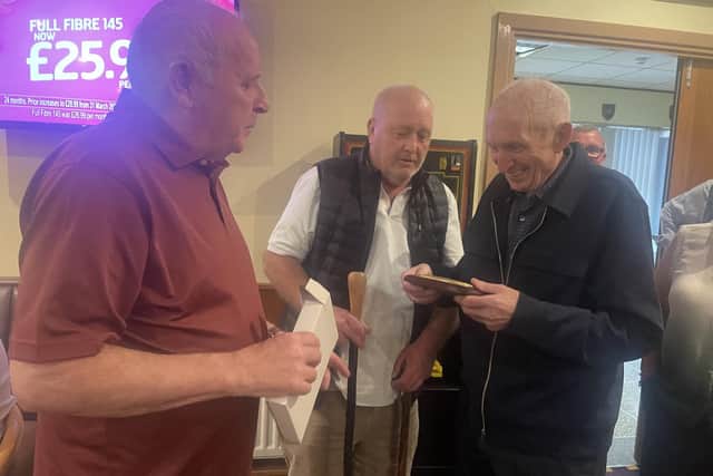 Chairman of the Lisburn branch of the Royal British Legion, Brian Sloan, and Brian McKee present gifts to Gerry as he leaves Lisburn to live with family in England. Pic credit: NIWD
