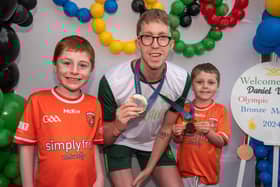 Young Armagh fans Conor Stevenson (8) and brother, Matthew (6) posing proudly with Daniel Wiffen. LM33-215.