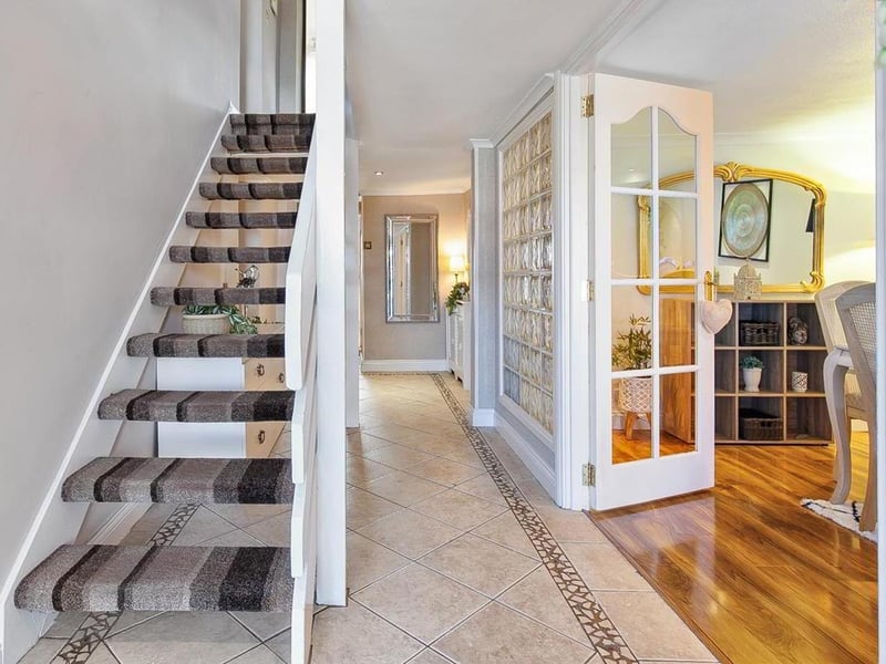 Entrance hall with tiled floor and stairwell to first floor.