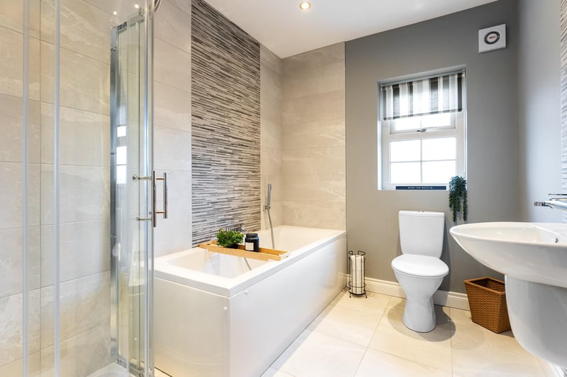 The stylish family bathroom has a tiled floor and partially tiled walls.