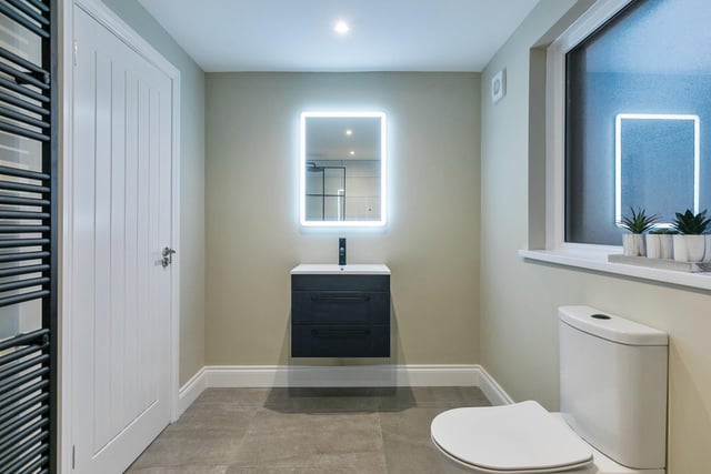 The ensuite features a vanity unit with illuminated mirror above.