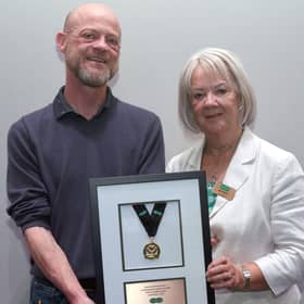 Dame Mary Perkins presenting store owner Brian O’Kane with the Dame Mary Perkins Medal for Outstanding Customer Care. Credit: Rob Lacey Photographer