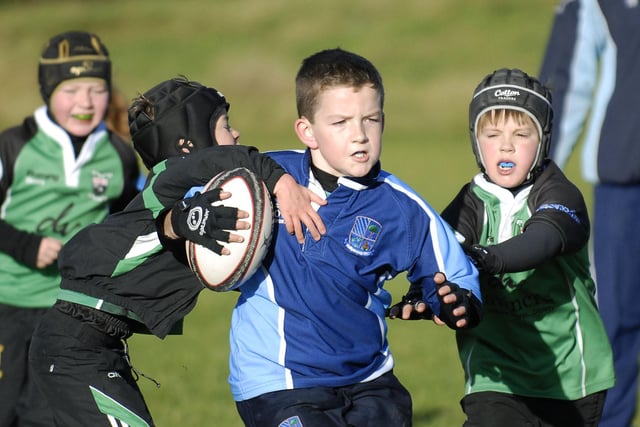 A Ballymoney youngster holds off these City of Derry tackles during their mini-rugby match at Judges Road back in 2011.