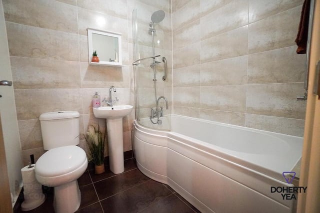 Modern tiled bathroom with white suite.