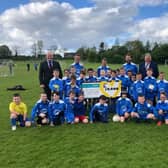 Centra Carryduff owners Jonathan Boal (far left) and David Martin (far right) visit the Carryduff Colts. They are joined by (from second left, to right) coaches Mark Hanvey, Paul Kernaghan and Graham Parkinson, plus the 2013 team