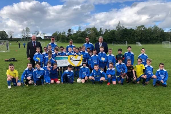 Centra Carryduff owners Jonathan Boal (far left) and David Martin (far right) visit the Carryduff Colts. They are joined by (from second left, to right) coaches Mark Hanvey, Paul Kernaghan and Graham Parkinson, plus the 2013 team