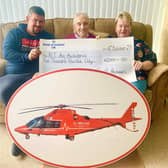 Cyril, Jason and Anne pictured with Cyril's donation to Air Ambulance NI. Credit AANI