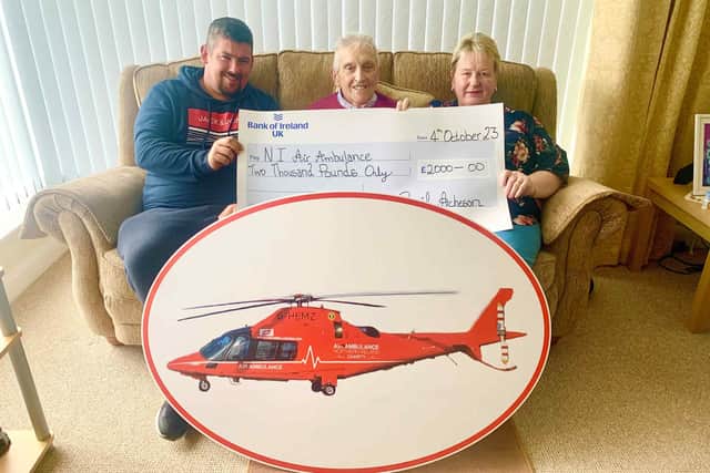Cyril, Jason and Anne pictured with Cyril's donation to Air Ambulance NI. Credit AANI