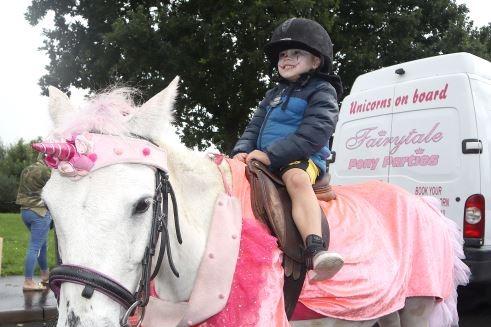A young jockey enjoying the pony rides.
