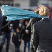 People walk in strong winds.