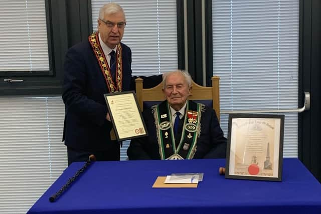 Sir Knight Hilbert Willis receives his certificate marking his 100 th birthday and 80 years of service from Sovereign Grand Master Rev William Anderson