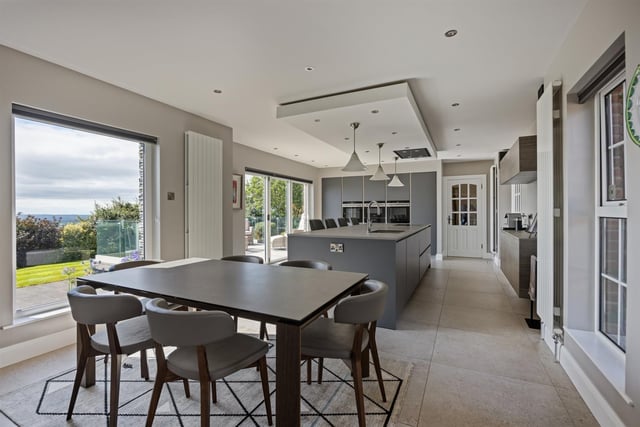 Kitchen with luxury, Robinson Interiors 'Rational' fitted kitchen, with range of high and low level storage units, matching island unit, and Neolith porcelain worktops. Inlaid stainless steel sink unit, breakfast bar area, and comprehensive range of Siemens integrated appliances.  Dual aspect windows, enjoying elevated rural views towards Cave Hill. Bifold doors, leading to patio area and garden. Glass panelled door leading to rear hall.