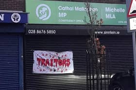 The banner accusing Sinn Féin of being "traitors" has been put up at the office of the party's deputy leader Michelle O'Neill in Cookstown. The banner was stuck to the office shutters after O'Neill laid a laurel wreath at the Cenotaph at Belfast City Hall on Sunday, becoming the first senior Sinn Féin figure to take part in an official Remembrance ceremony. Credit: Pacemaker