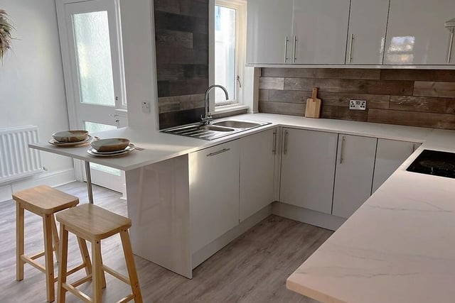 The contemporary grey gloss fitted kitchen with breakfast bar.