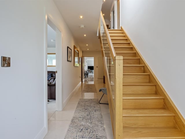 Entrance hall with PVC double glazed front door, tiled floor, and dual aspect windows, enjoying rural views. Stairwell to first floor, with glass balustrade.