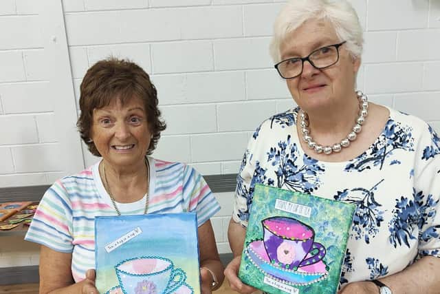Sisters Ethel Simpson and Linda Wright showing their collaged canvas art. Photo courtesy of Glenlough Community Centre
