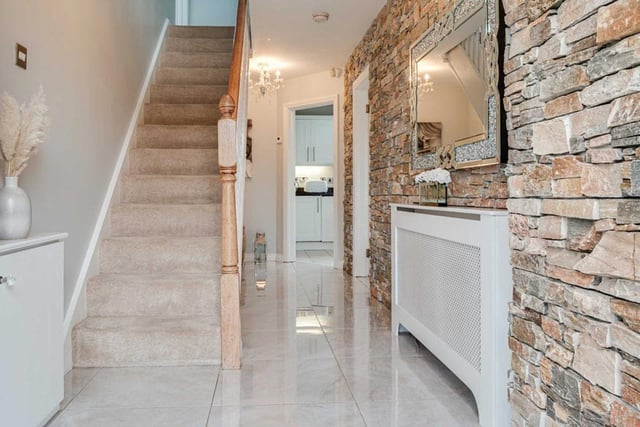 Reception hall with feature exposed stone clad wall and porcelain tiled floor.