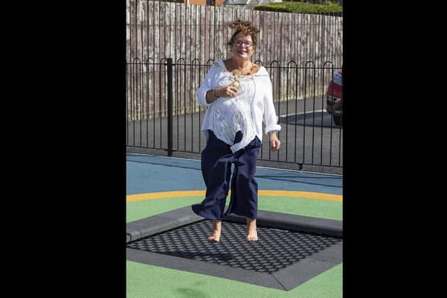 Mayor, Alderman Gerardine Mulvenna tries out the refurbished play park area at Ferris Park in Larne.