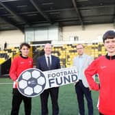 Communities Minister Gordon Lyons pictured at Blanchflower Stadium with Graham Fitzgerald, Chief Operating Officer at the Irish Football Association, and Jake and Leon from Ashfield Boys' High School. (Photo by Department for Communities)