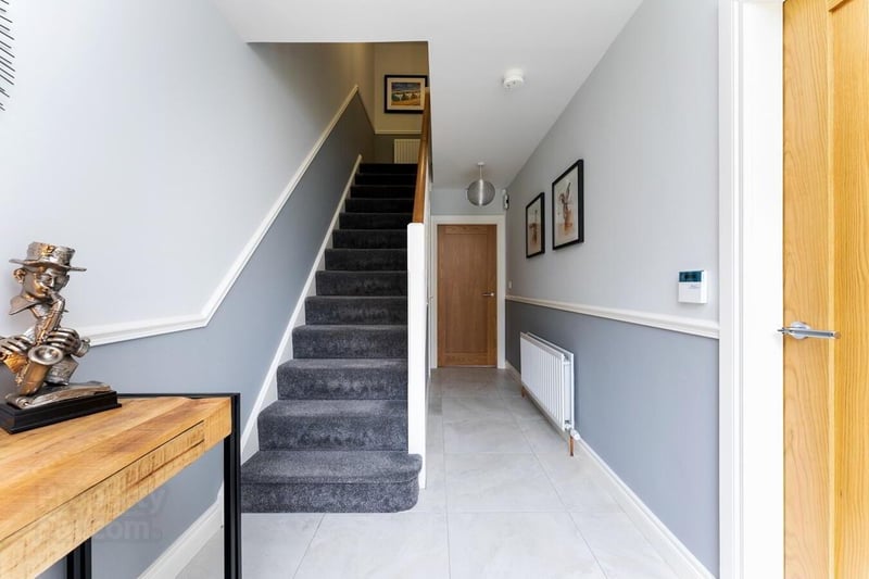 The attractive hallway has a tiled floor and under stair storage.
