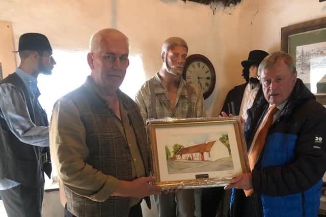 Colin Winter presenting Fraser Agnew with a painting of the cottage by Colin’s mother, the late Mrs Greta Winter. (Pic: Contributed).