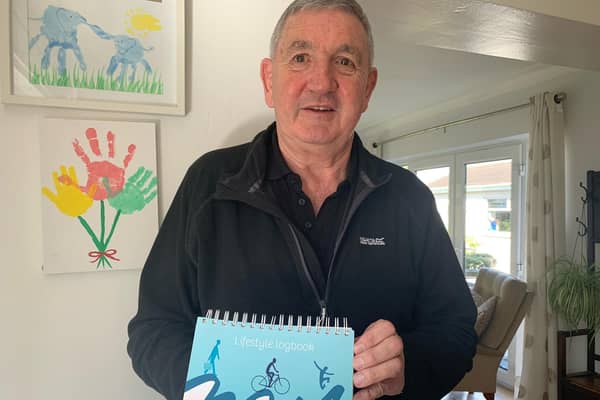 Peter at his Saintfield home with his Lifestyle log book. Pic credit: SEHSCT