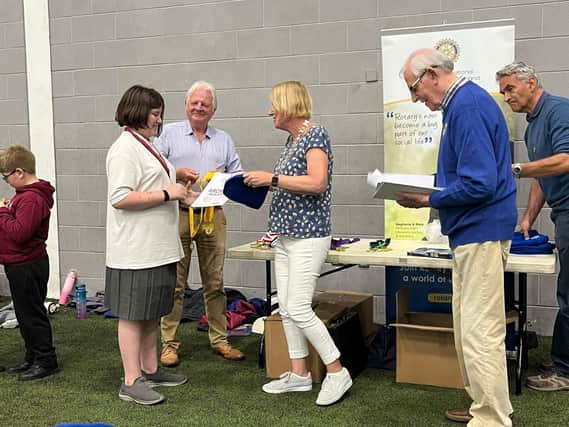 One of the young prize winners receiving their medal and certificate at the recent Rotary Kids for Fun archery day at Jordanstown.