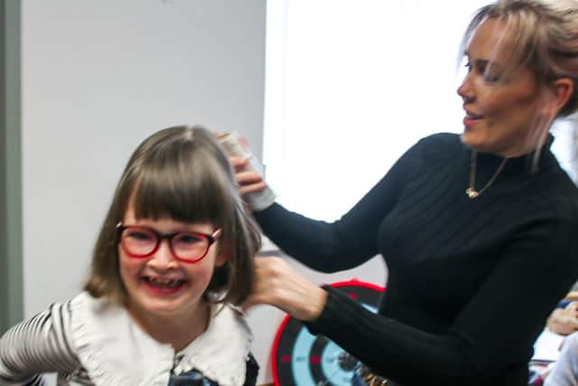 The finishing touches to Emily's new hairstyle.