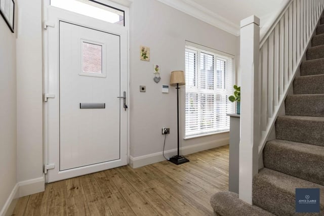 The bright entrance hall has a composite entrance door with glazed panel above. There is wood effect tiled flooring and under stair storage.
