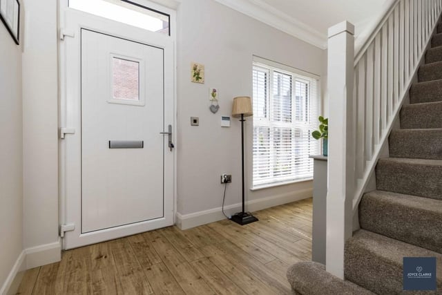 The bright entrance hall has a composite entrance door with glazed panel above. There is wood effect tiled flooring and under stair storage.