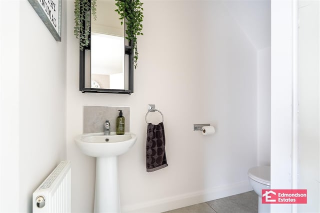 Cloakroom with modern fitted two piece suite comprising wash hand basin and WC.
