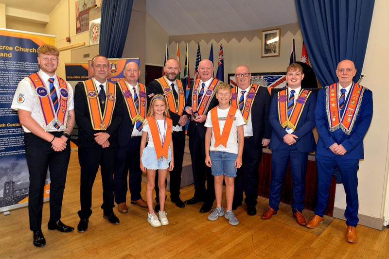 Gary McIvor, fourth right, of Parkmount LOL 127 receives his 25-year diamond from Deputy District Master, Alistair Power. Also included are lodge members and Gary's children, Flossie-Bo and Frankie. PT28-205.
