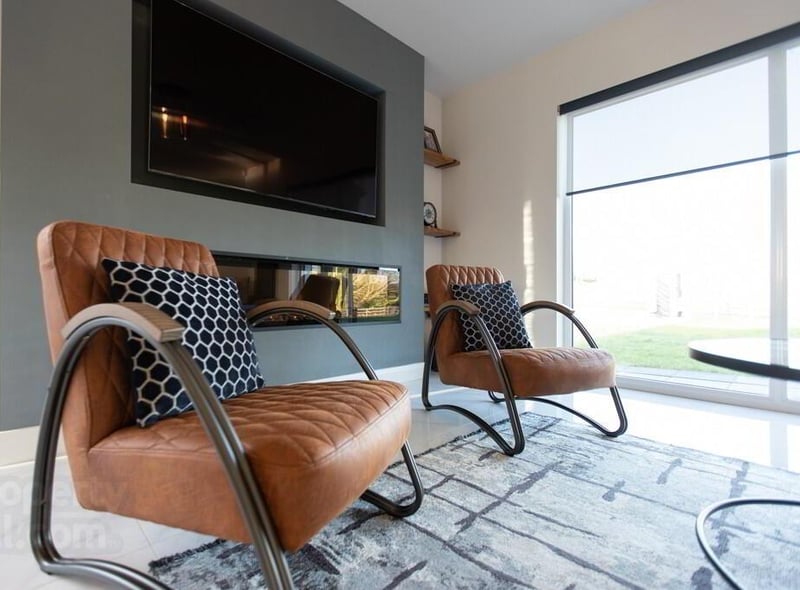 The living area is decorated in stylish modern tones and features an electric fire for cosy evenings in.