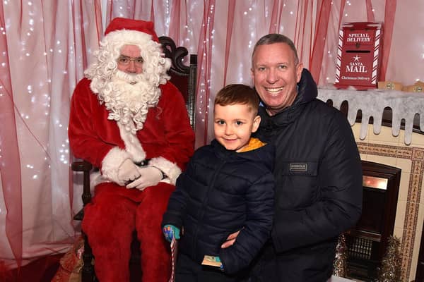 Looking happy with Santa at his grotto in St Mark's Church tower are Freddie Irwin and dad Neil. PT50-227.