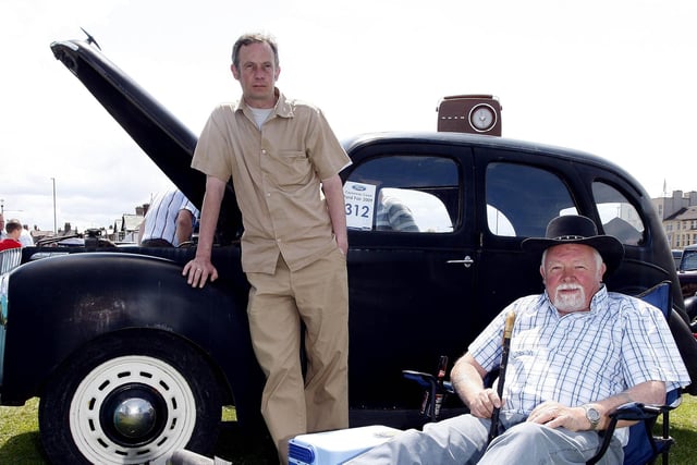 Gerald Dallat and his son Gerard relax with their 1952 Prefect during the Ford Fair at the Dunluce Centre in 2009.